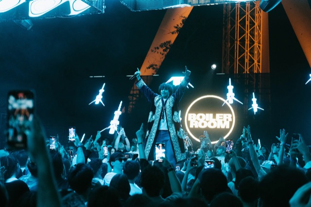 An artist in a traditional chapan performing in the crowd