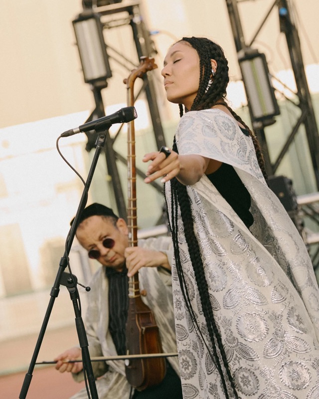 A vocalist and a traditional string player performing at Sublimation